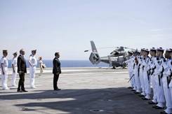 France's President Nicolas Sarkozy (C) reviews the troops with Defence Minister Gerard Longuet (3rd L) on the deck of the aircraft carrier Charles de Gaulle August 12, 2011, as it returns to the port of Toulon for maintenance after participating in the...