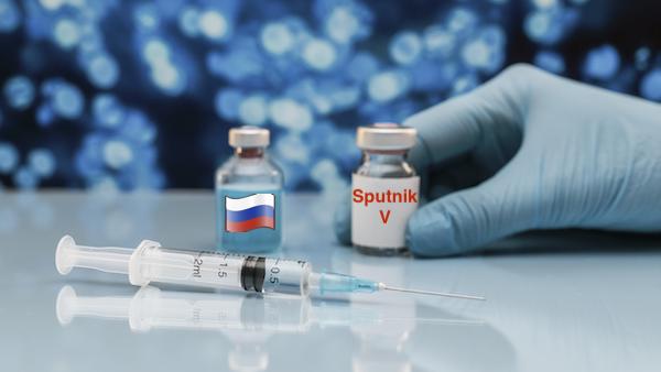 syringe vaccine bottle table with hand glove Sputnik V